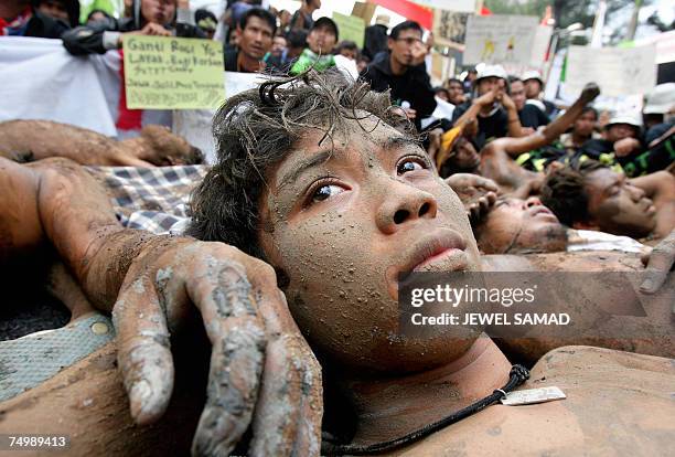 Jakarta, Java, INDONESIA: Environmental activists cover themselves with mud during a demonstration against Lapindo Brantas, a company linked to...