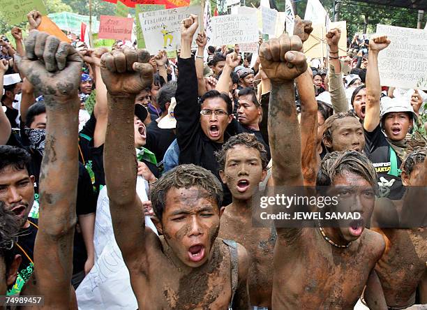 Jakarta, Java, INDONESIA: Environmental activists covered with mud shout slogans along with others during a demonstration against Lapindo Brantas, a...