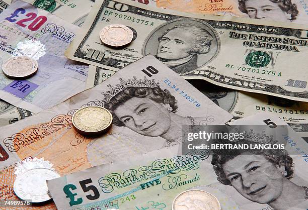 London, UNITED KINGDOM: A picture taken 17 April 2007 in London shows several US dollar and UK sterling notes and coins. The pound struck a 26-year...