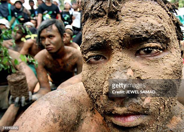 Jakarta, Java, INDONESIA: Environmental activists covered with mud protest against Lapindo Brantas, a company linked to Indonesia's welfare minister,...