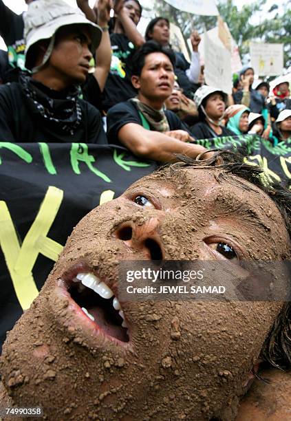 Jakarta, Java, INDONESIA: Environmental activists, one covered with mud, shout slogans during a demonstration against Lapindo Brantas, a company...