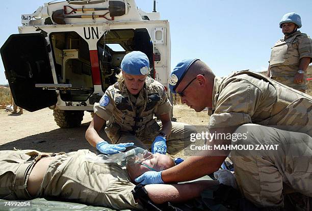 Belgian soldiers treat a mock wounded colleague during a drill attended by Defence Minister Andre Flahaut near their camp in the southern Lebanese...