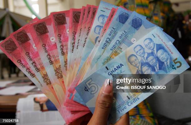 Woman holds 03 July 2007 in Accra a wad new currency, the new cedi, that Ghana put in circulation that day, although the old money will still be...