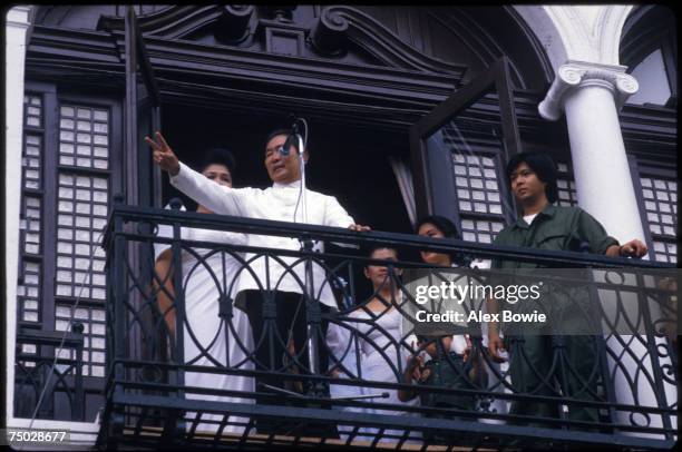 Watched by First Lady Imelda Marcos , Philippine President Ferdinand Marcos waves to supporters from a balcony of the Malacanang Palace in Manila...