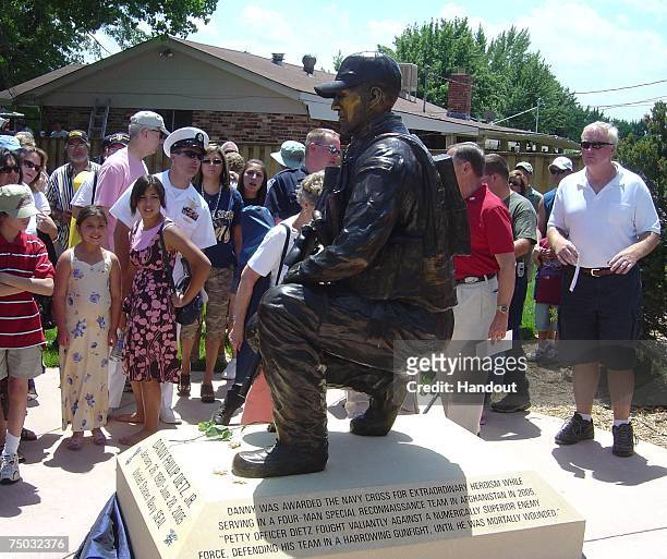 In this handout photo provided by the U.S. Navy, a statue of Gunner's Mate 2nd Class Danny P. Dietz is dedicated in a park near his childhood family...