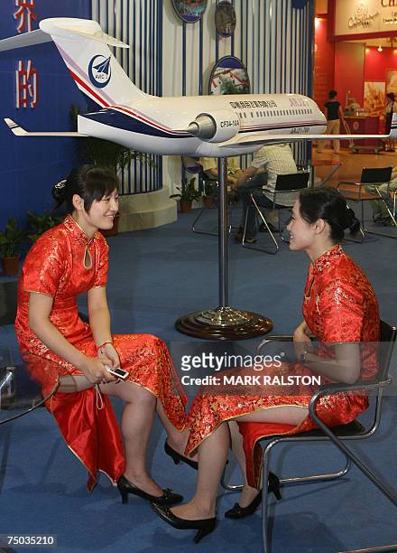 Chinese models sit beside the 90 seat ARJ-21 which is the first Chinese developed commercial jet, at an aviation and space exhibition in Shanghai, 05...