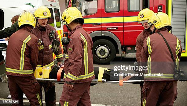 An injured passenger is carried by fire brigade officers after evacuation from Mile End station on July 5, 2007 in London. Up to six carraiges of a...