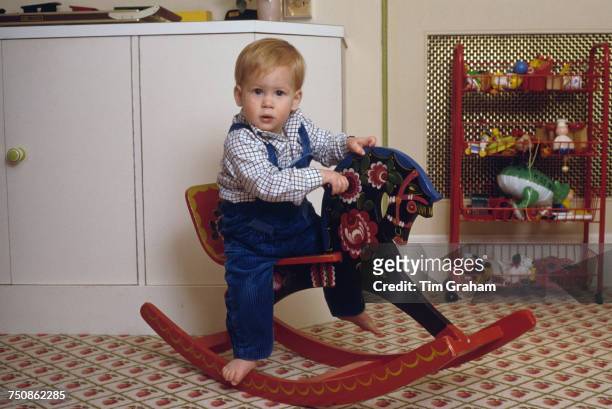 Prince Harry on a rocking horse in the playroom at Kensington Palace, London, 22nd October 1985.