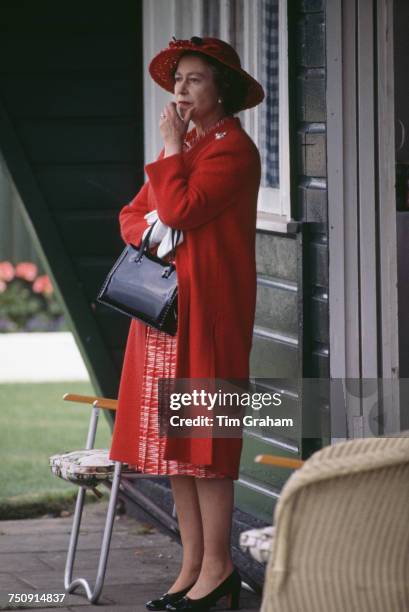 Queen Elizabeth II watching a polo match at Windsor after a day at the Ascot races, 17th June 1980.