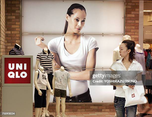 Customers passes before a Uniqlo shop, Japan's casual wear giant operated by the Fast Retailing in Tokyo 06 July 2007. Fast Retailing offered 900...