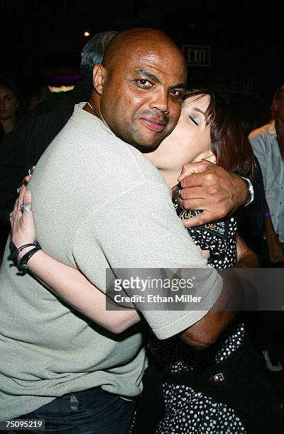 Analyst and former NBA player Charles Barkley is kissed by poker player and event co-host Annie Duke at the after party for the Ante Up for Africa...