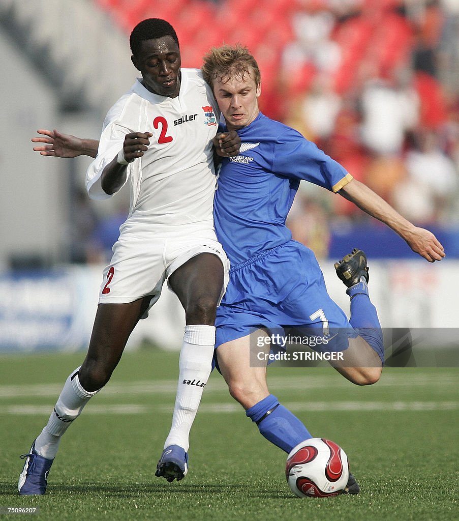 Gambia's Pierre Gomez (L) collides with...