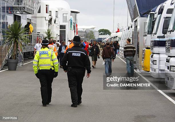 Silverstone, UNITED KINGDOM: British policemen patrol the paddock of the Silverstone racetrack, 06 July 2007 in Silverstone, during the second...
