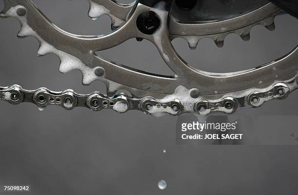 London, UNITED KINGDOM: Picture shows drops of water falling from the chain of an Astana professionnal bike as it is being washed, on the eve of the...