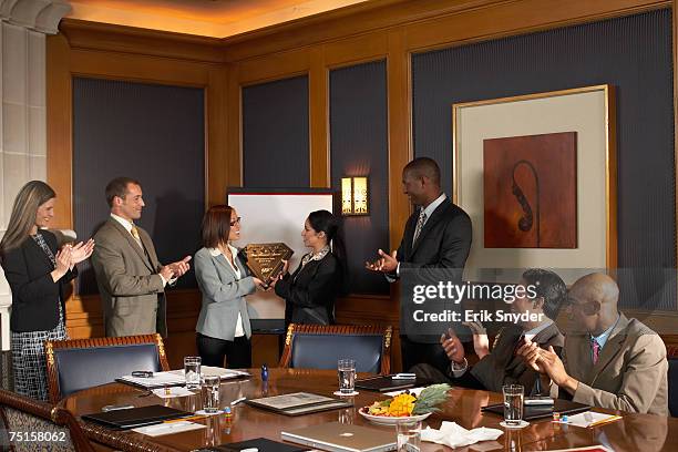 business people in conference room, business women receiving award while colleagues applaud - receiving award stock pictures, royalty-free photos & images