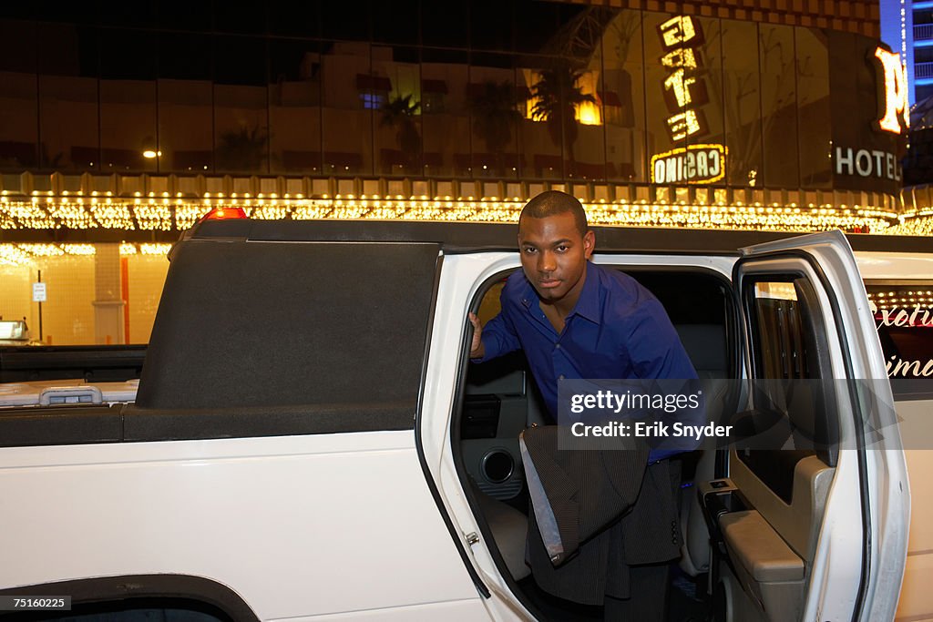 Man leaving limousine in front of casino, portrait