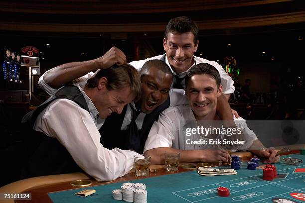 four men sitting in casino playing roulette, smiling - festa di addio al celibato foto e immagini stock