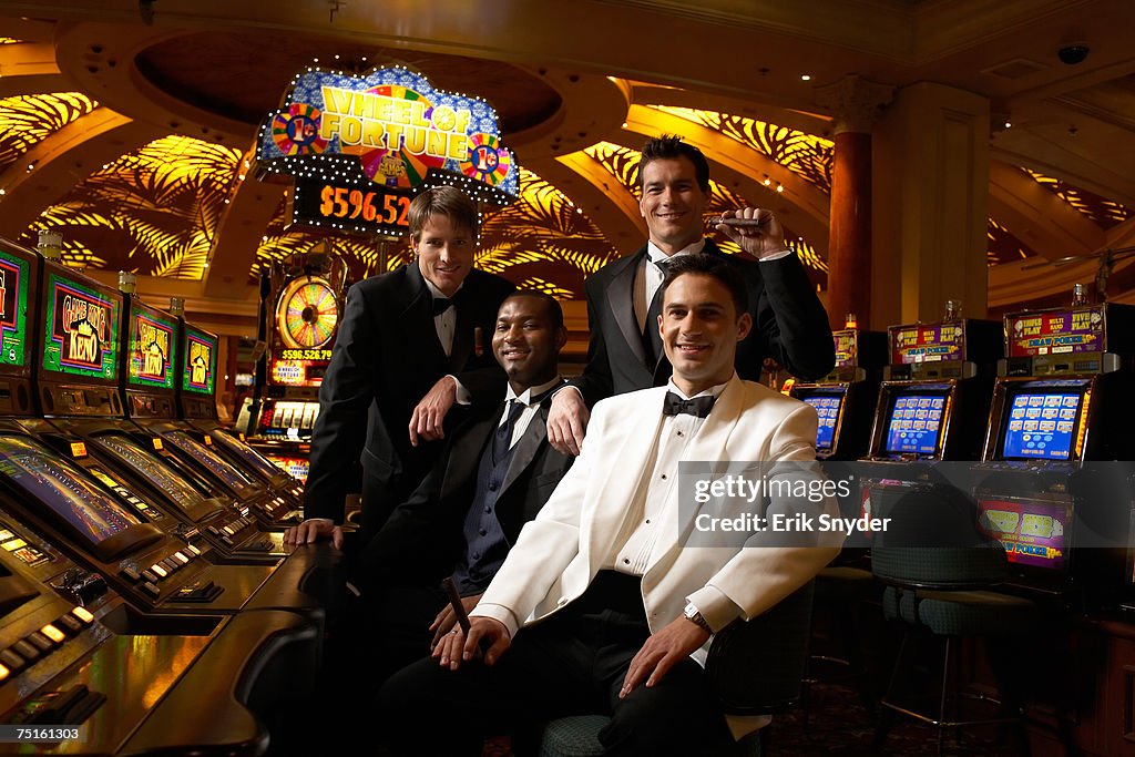 Group portrait of men sitting at casino slot machine. smiling