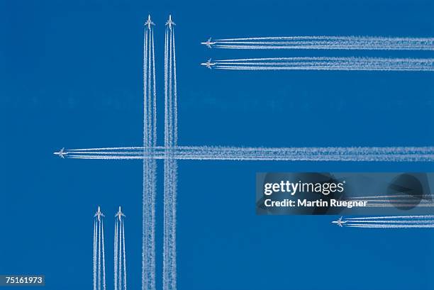 jets with vapour trails in blue sky, view from below (digital composite) - espectáculo aéreo fotografías e imágenes de stock