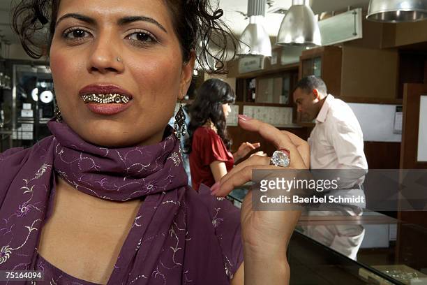 woman with gold teeth in department store, close-up of woman - capped tooth stock-fotos und bilder
