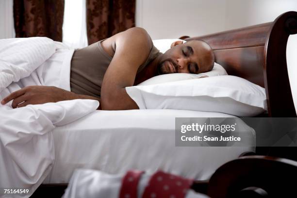 mature man sleeping in bed - lying on side stock pictures, royalty-free photos & images