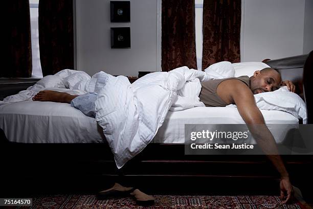 mature man sleeping in bed - men in bed stock-fotos und bilder
