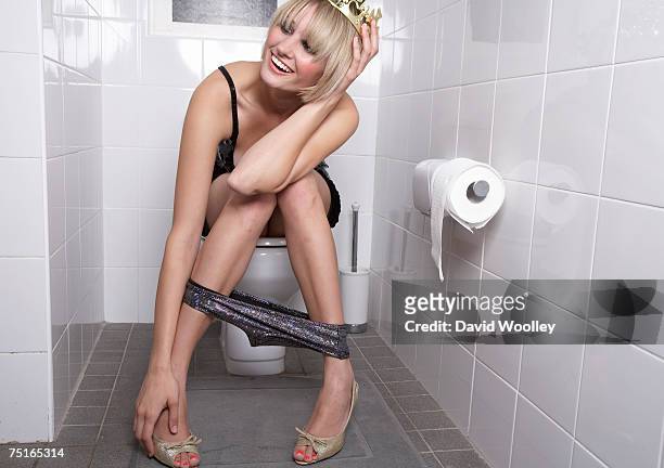young woman wearing crown sitting on toilet, laughing - people peeing 個照片及圖片檔