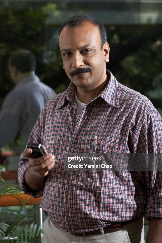 Businessman using cellphone, portrait