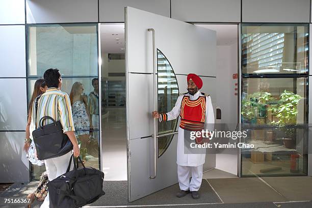 businesspeople entering in office - door attendant stock pictures, royalty-free photos & images