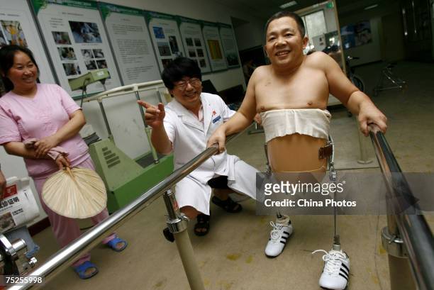 Peng Shuilin learns to walk as his wife and doctor look on at the China Rehabilitation Research Center on July 6, 2007 in Beijing, China. 49-year-old...