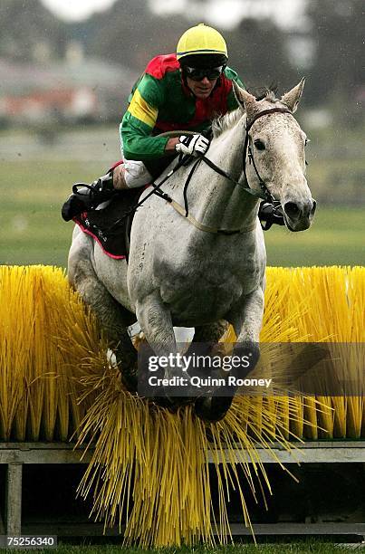 Adam Trinder riding Swift Rule jumps a hurdle to finish third during the Cleanevent Grand National Steeplechase during the Grand National Steeple...