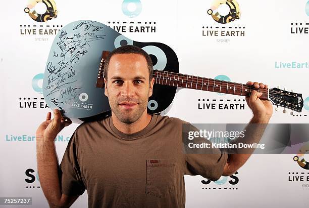 Musician Jack Johnson poses backstage with a signed Live Earth guitar at the Australian leg of the Live Earth series of concerts, at Aussie Stadium,...
