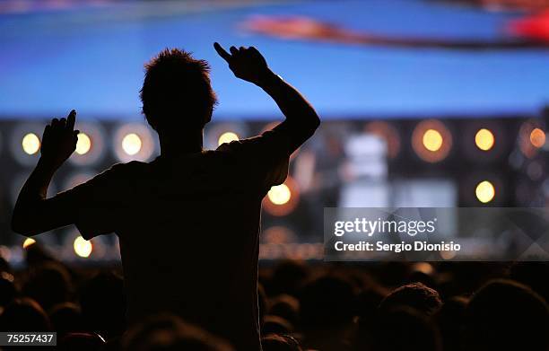 Fan watches Wolfmother on stage at the Australian leg of the Live Earth series of concerts, at Aussie Stadium, Moore Park on July 7, 2007 in Sydney,...