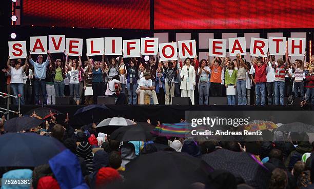 Childs hold up letters that reads "SaveLifeOnEarth" during the Hamburg Live Earth concert at the HSH Nordbank Arena on July 7, 2007 in Hamburg,...