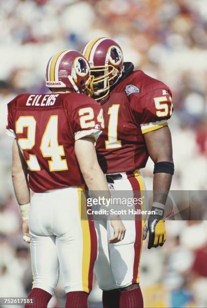 Monte Coleman, linebacker for the Washington Redskins taps helmets and makes eye contact with team mate Pat Eilers during their National Football...