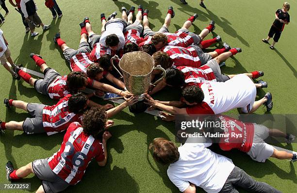 Club an der Alster team lays on the field with the trophy for the German Field Hockey Champion after winning the men?s final match against...