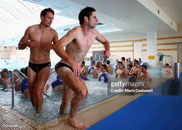 Shannon Watt and Brady Rawlings of the Kangaroos leave the water during a Kangaroos AFL recovery session at St Kilda Sea Baths on July 9, 2007 in...