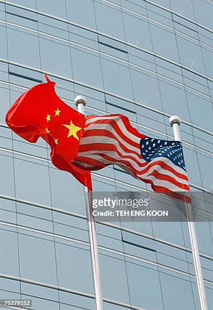 And a Chinese flag wave outside a commercial building in Beijing, 09 July 2007. US Secretary of State Condoleezza Rice 06 July 2007 accused China of...