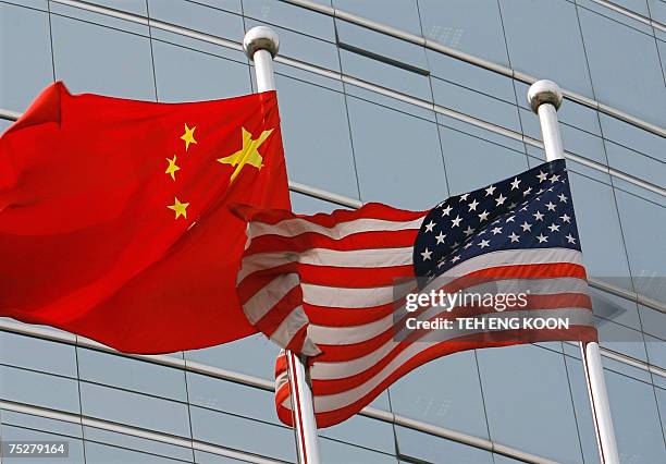 And a Chinese flag wave outside a commercial building in Beijing, 09 July 2007. US Secretary of State Condoleezza Rice 06 July 2007 accused China of...