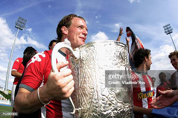 Max Landshut of Alster holds the trophy during celebrations after the German Field Hockey Championship men?s final match between Uhlenhorster HC and...
