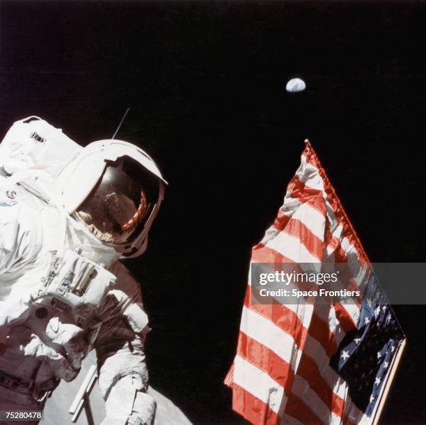 American geologist and Apollo 17 astronaut Harrison Hagan Schmitt stands next to the US flag on the surface of the moon, during a period of EVA at...