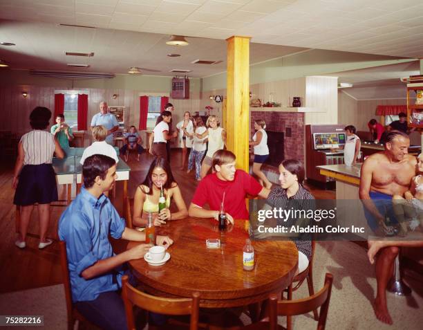 General view of people engaged in a variety of 'entertaining' activities in the social room of the Pine Lake Manor hotel, Greenville, New York, mid...