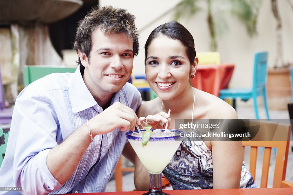 Couple sitting in restaurant, smiling