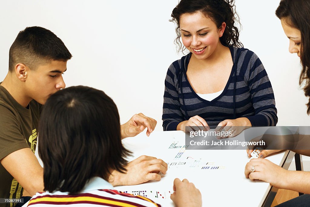 Friends (12-15) sitting around table, smiling