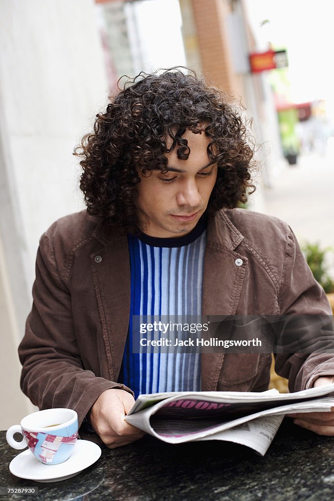 Young man reading newspaper