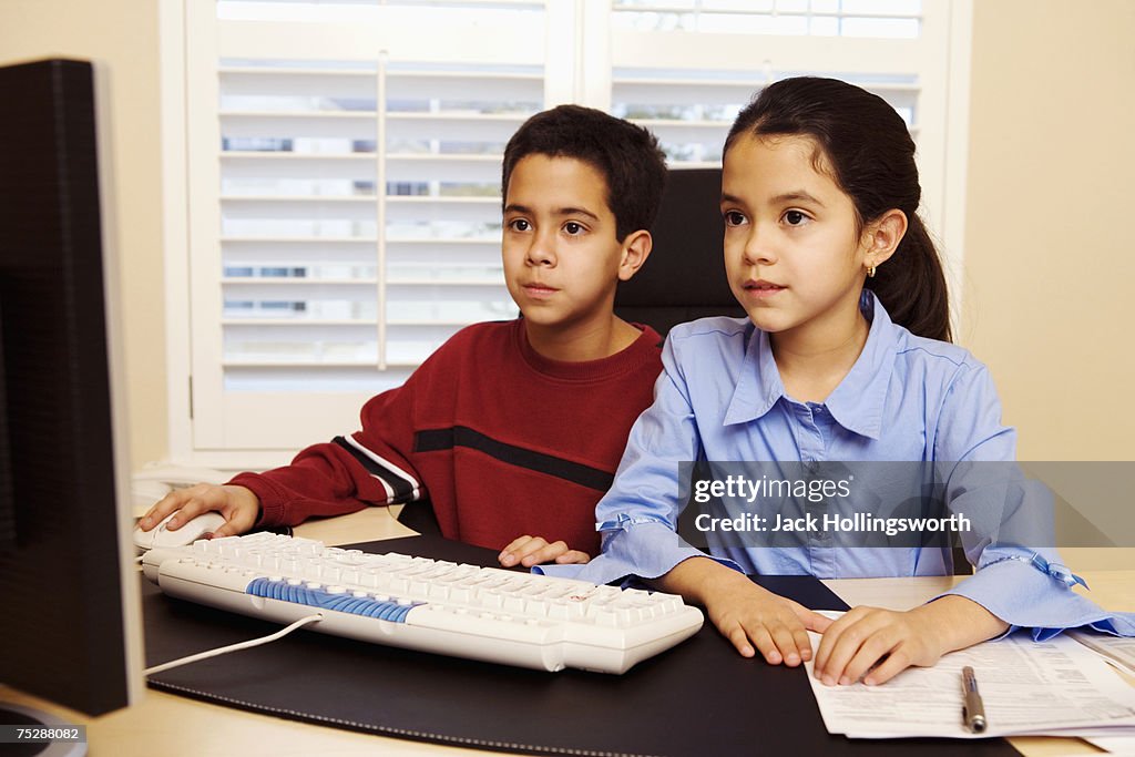 Children (8-11) in front of computer, looking at monitor