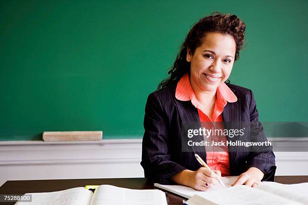 teacher writing, smiling, portrait - teacher desk foto e immagini stock