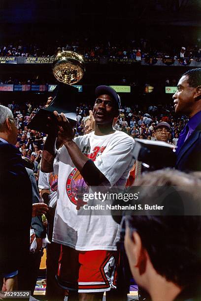 Michael Jordan of the Chicago Bulls poses with his NBA Finals MVP trophy after winning the 1998 NBA Championship after defeating the Utah Jazz in...
