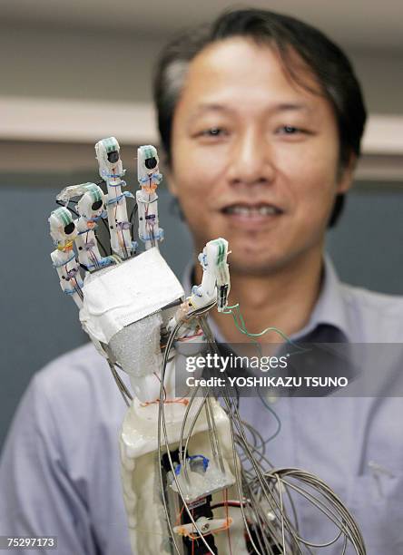 Tokyo University Associate Professor Hiroshi Yokoi displays a robot hand which is able to grip a raw egg and crush an aluminium can, at his...