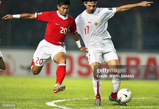 Jakarta, Java, INDONESIA: Bahrain's Husein Baba vie for the ball with Indonesian Bambang Pamungkas during the Asian Cup 2007 Group D football match...